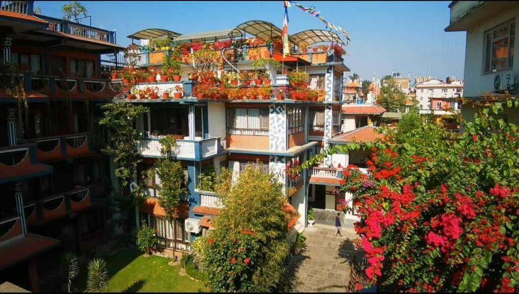 Boudha Orange Hotel garden building with flowering balconies in Boudha, Kathmandu